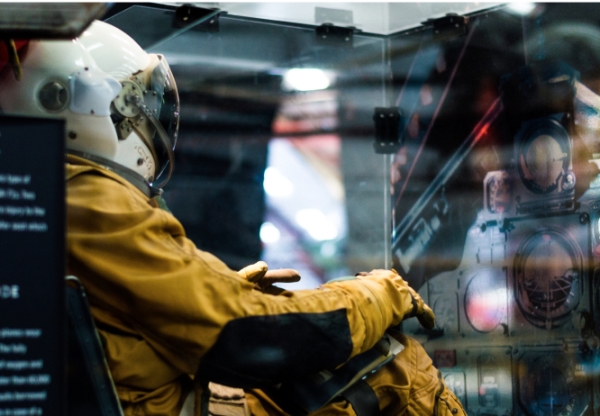 Boy wearing a helmet and full suit in a space like air craft