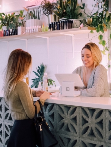 Woman shopping and interacting with shop assistant